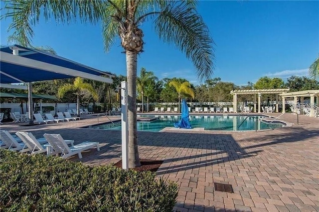 pool with a patio area and a pergola