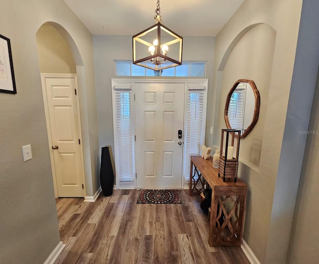 foyer entrance featuring an inviting chandelier and hardwood / wood-style flooring