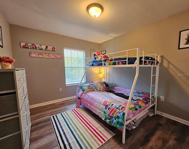 bedroom featuring a textured ceiling and dark hardwood / wood-style flooring