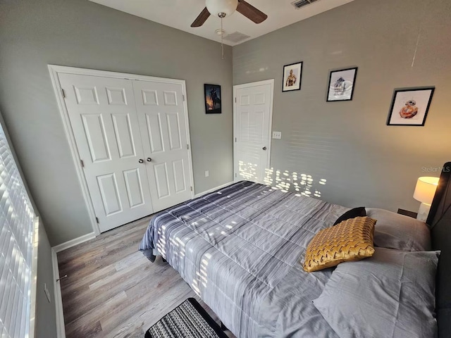 bedroom with hardwood / wood-style floors, ceiling fan, and a closet