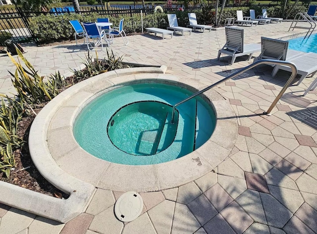 view of pool featuring a community hot tub and a patio