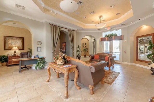 interior space with a tray ceiling, crown molding, and light tile patterned flooring