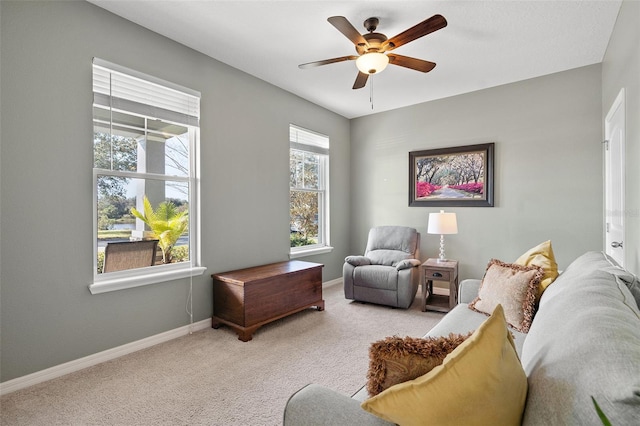 sitting room with ceiling fan and light colored carpet