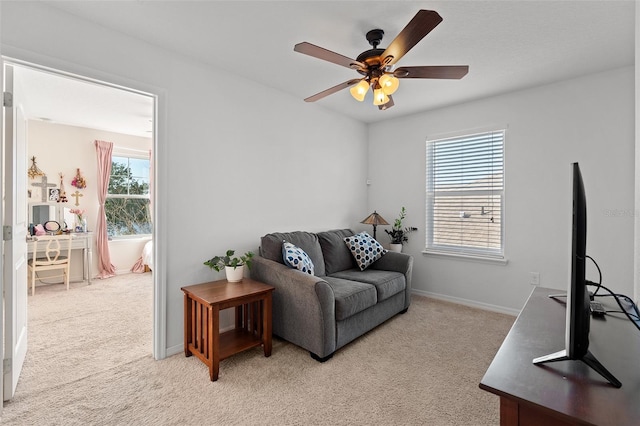 carpeted living room with ceiling fan