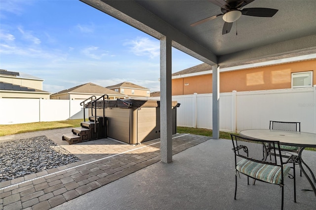 view of patio featuring ceiling fan and a hot tub