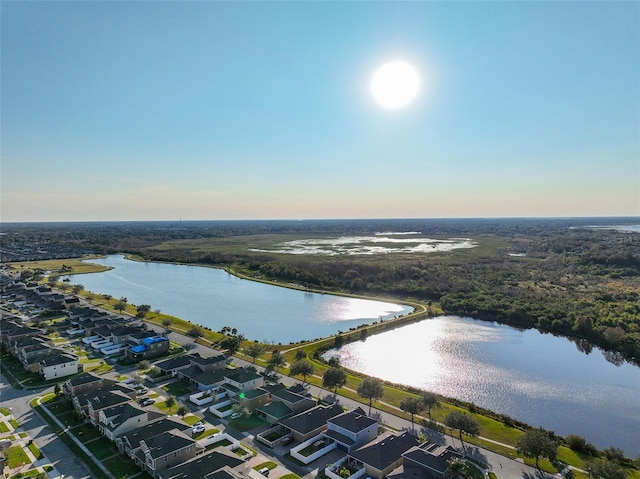 aerial view at dusk featuring a water view