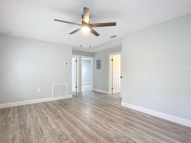 spare room with light hardwood / wood-style floors, electric panel, and ceiling fan