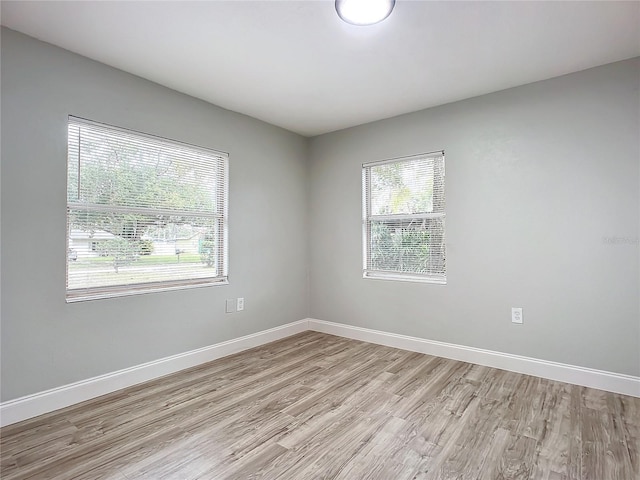 empty room with a healthy amount of sunlight and light hardwood / wood-style floors