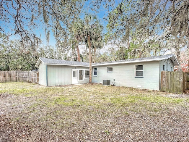 back of house with a lawn and central air condition unit