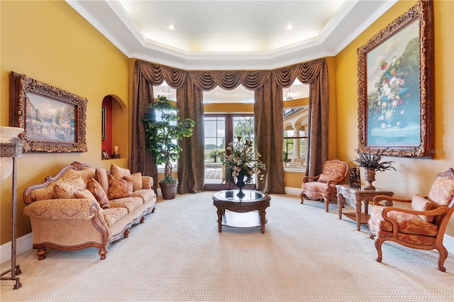 sitting room with carpet floors, a tray ceiling, and crown molding