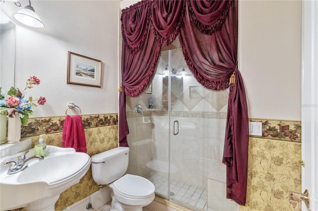 bathroom featuring sink, an enclosed shower, and toilet