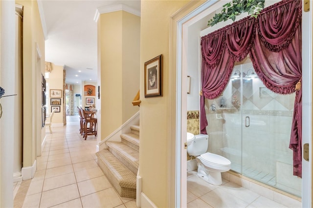 bathroom featuring toilet, an enclosed shower, ornamental molding, and tile patterned floors