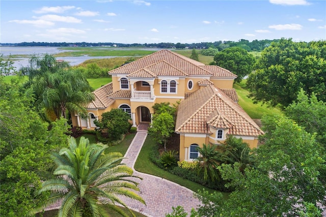 view of front of property featuring a balcony and a water view