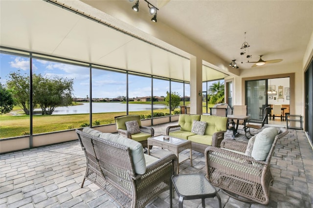 sunroom with a water view, plenty of natural light, and ceiling fan