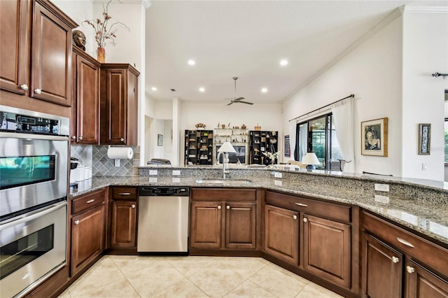 kitchen with stone counters, sink, ceiling fan, stainless steel appliances, and light tile patterned floors