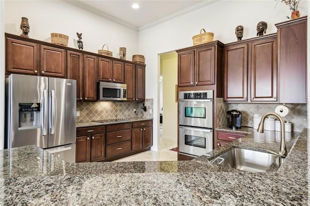 kitchen featuring decorative backsplash, appliances with stainless steel finishes, ornamental molding, sink, and dark stone countertops