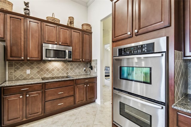 kitchen featuring light tile patterned floors, ornamental molding, tasteful backsplash, light stone counters, and stainless steel appliances