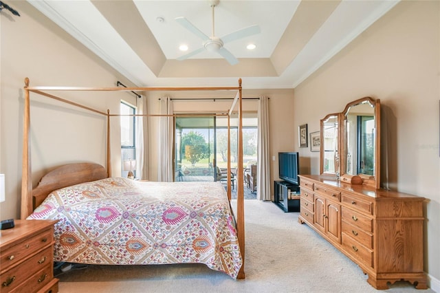 carpeted bedroom with access to exterior, a raised ceiling, and ceiling fan