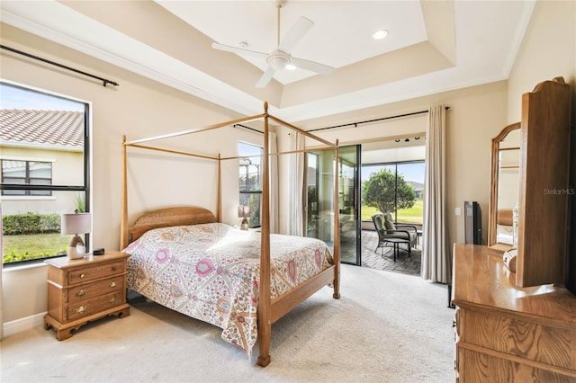 bedroom with access to exterior, carpet, a tray ceiling, and ceiling fan