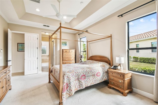 carpeted bedroom with ceiling fan, connected bathroom, and multiple windows