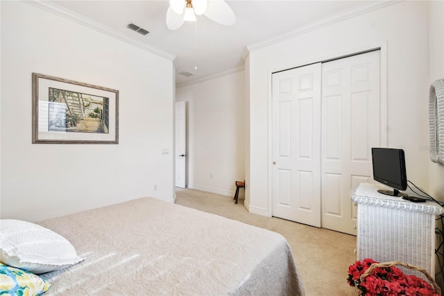 carpeted bedroom with a closet, ceiling fan, and crown molding