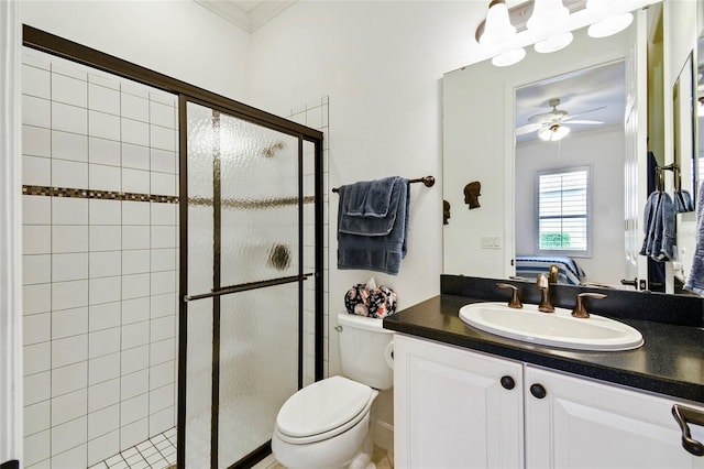 bathroom with vanity, ceiling fan, toilet, ornamental molding, and a shower with shower door