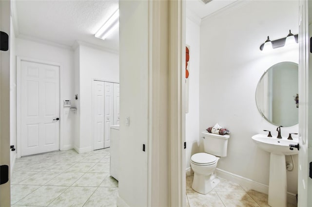 bathroom featuring tile patterned floors, toilet, crown molding, and a textured ceiling