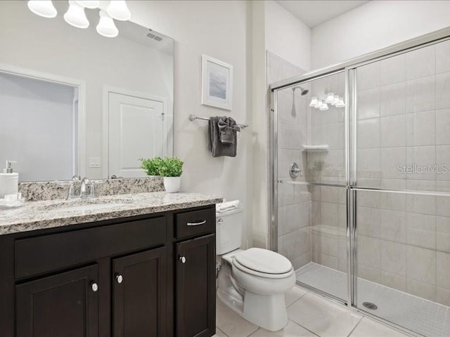 bathroom featuring a shower with door, vanity, tile patterned floors, and toilet