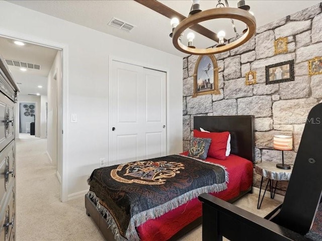 carpeted bedroom with an inviting chandelier and a closet