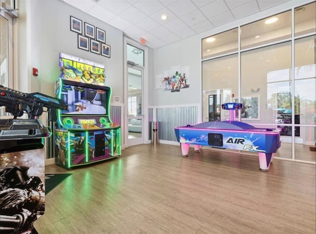 game room with plenty of natural light, hardwood / wood-style floors, a paneled ceiling, and billiards