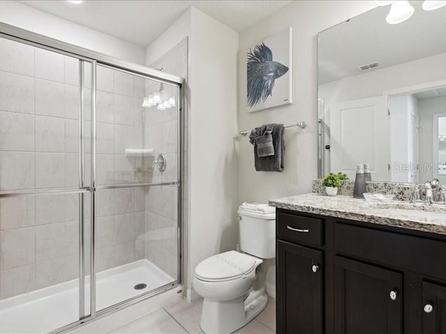 bathroom with vanity, a shower with door, tile patterned floors, and toilet