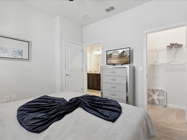 carpeted bedroom featuring a walk in closet, connected bathroom, and a closet