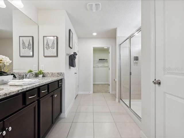 bathroom featuring walk in shower, vanity, and tile patterned flooring