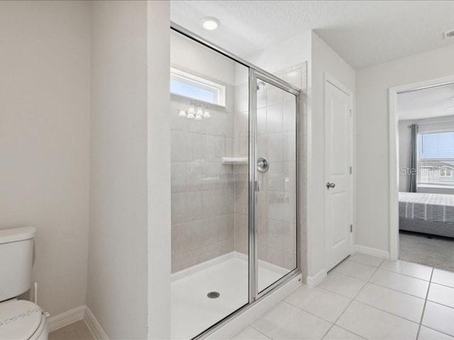 bathroom with a shower with door, tile patterned floors, and toilet