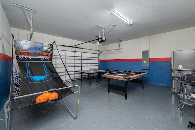 1607 Kona Ln, Davenport, FL 33897 - recreation room featuring electric panel, concrete block wall, a garage, a textured ceiling, and speckled floor