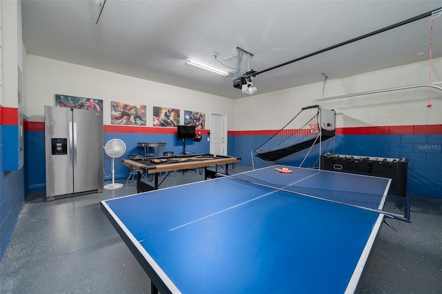 1607 Kona Ln, Davenport, FL 33897 - recreation room featuring a garage, concrete block wall, and speckled floor