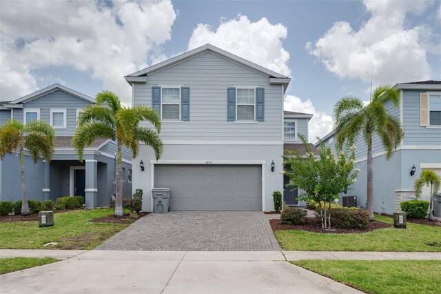 1607 Kona Ln, Davenport, FL 33897 - view of front of property with driveway, an attached garage, stucco siding, and a front yard