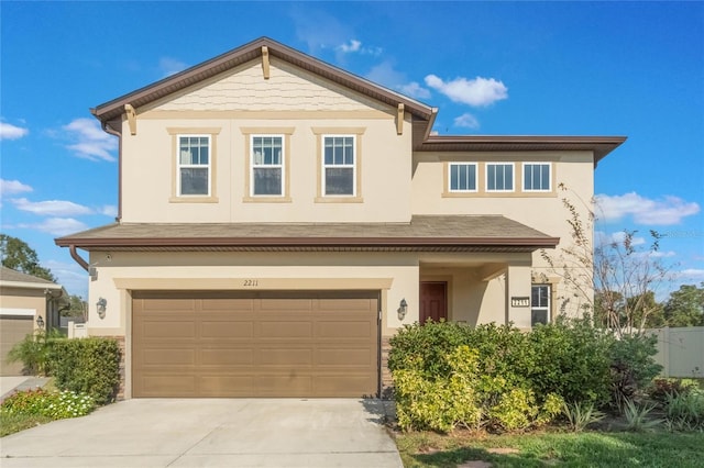 view of front of property with driveway, an attached garage, and stucco siding