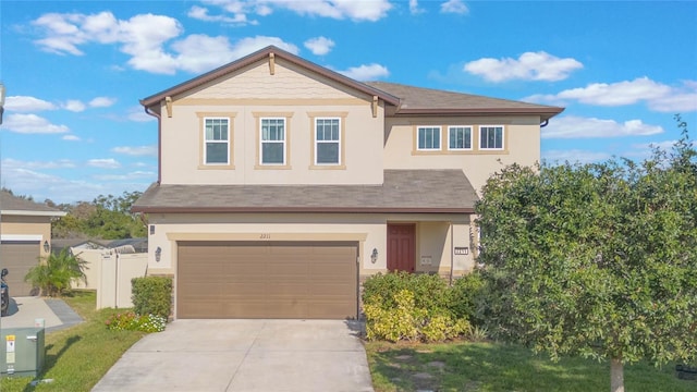 view of front of house featuring a garage, driveway, fence, and stucco siding