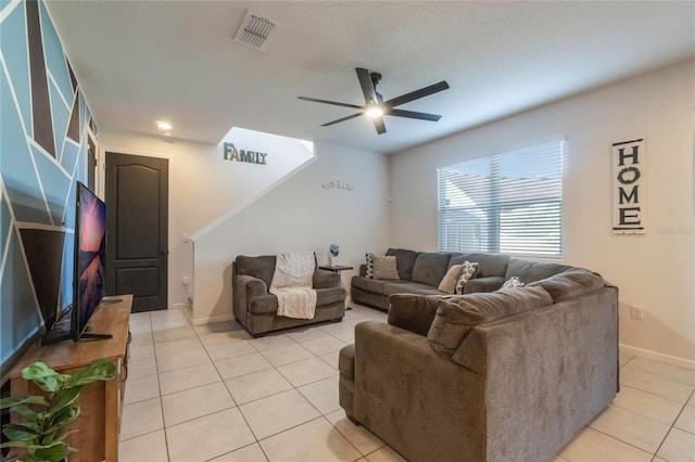 living room featuring baseboards, light tile patterned flooring, visible vents, and a ceiling fan