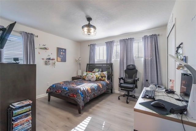 bedroom featuring light wood-type flooring and a textured ceiling