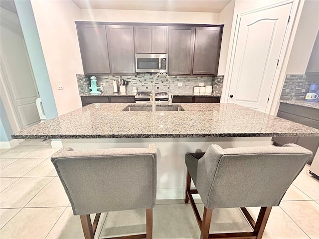 kitchen featuring a breakfast bar, light tile patterned flooring, and tasteful backsplash