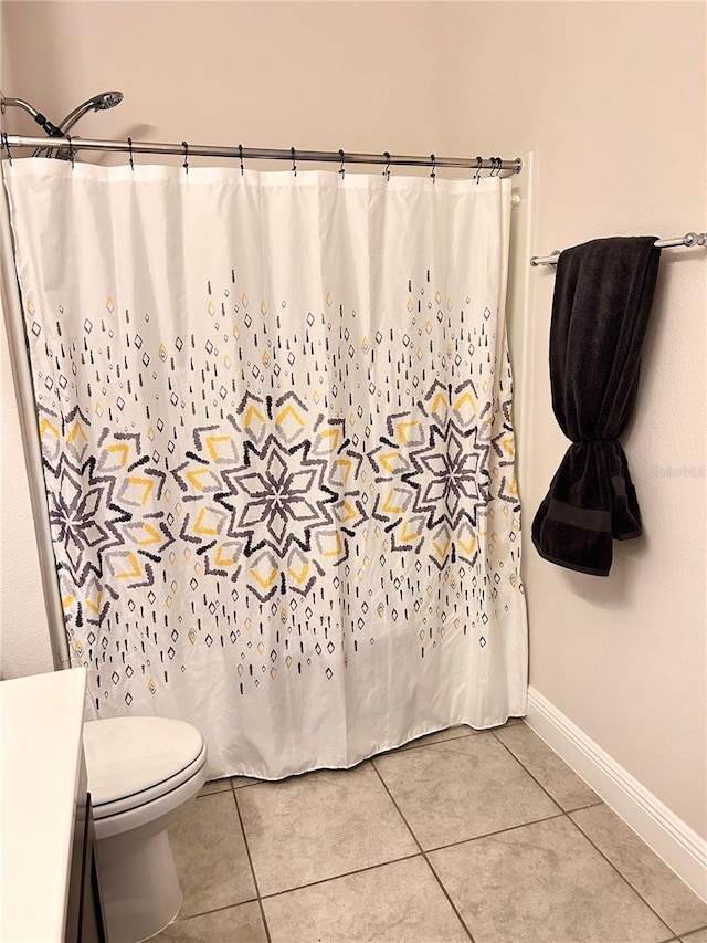 bathroom with tile patterned flooring, toilet, and walk in shower