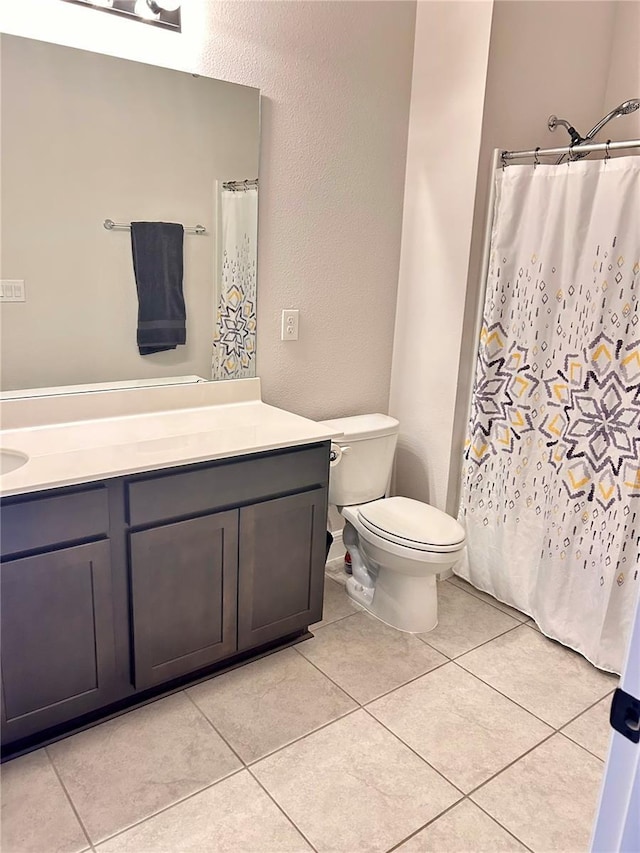 bathroom featuring tile patterned flooring, vanity, and toilet