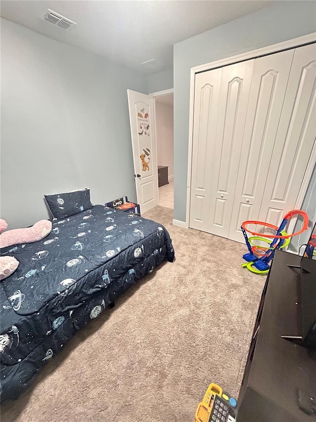 bedroom featuring light colored carpet and a closet