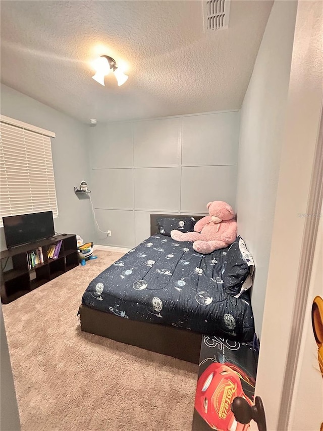 carpeted bedroom featuring a textured ceiling