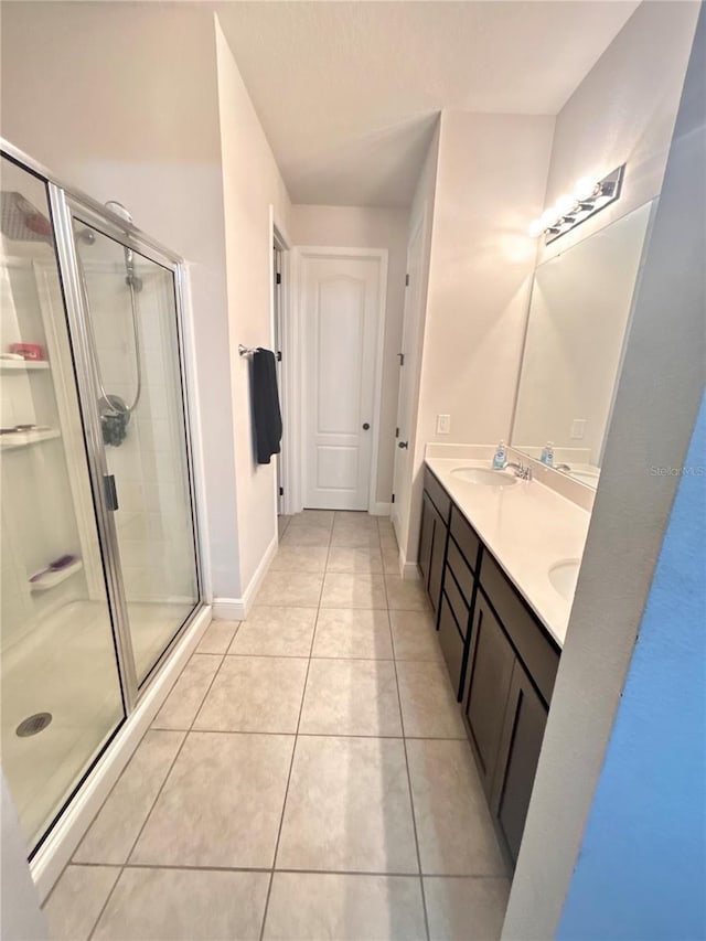 bathroom featuring tile patterned flooring, vanity, and a shower with shower door