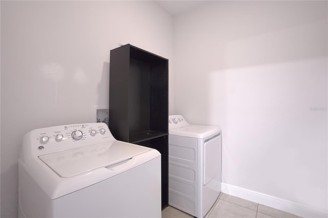 laundry area featuring washing machine and clothes dryer and light tile patterned floors