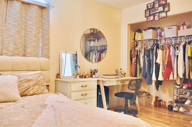 bedroom with light hardwood / wood-style floors and a closet