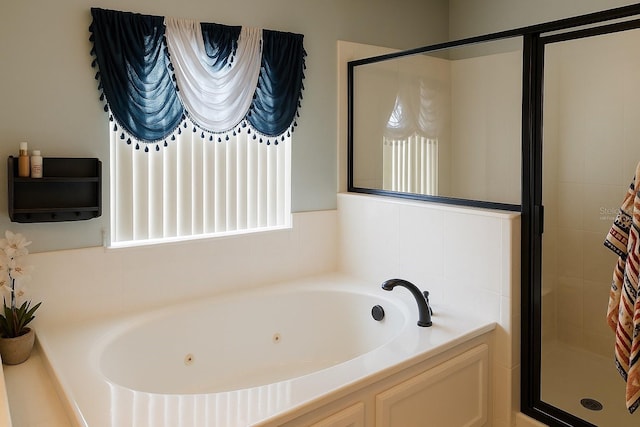 bathroom with a jetted tub and a stall shower